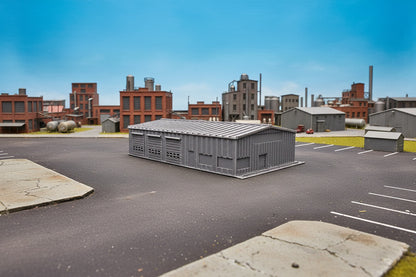 Model of a storage shed on grass with trees and sky in the background