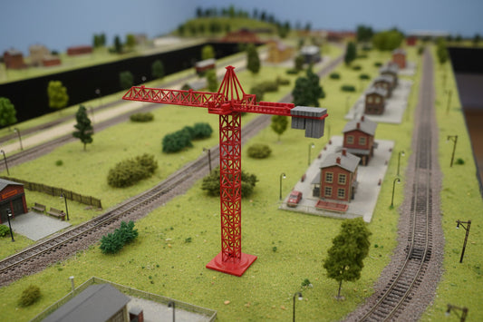 Red model crane on a textured white surface