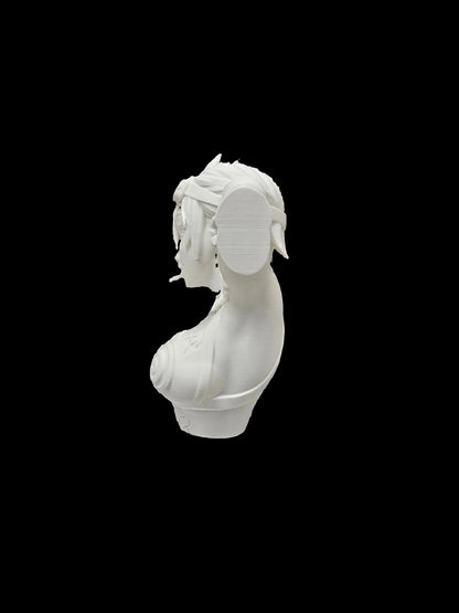 A white 3D-printed bust of a classical female head with a laurel wreath, displayed on a black and white miniature desk stand in front of a set of brown bookends shaped like antique books.