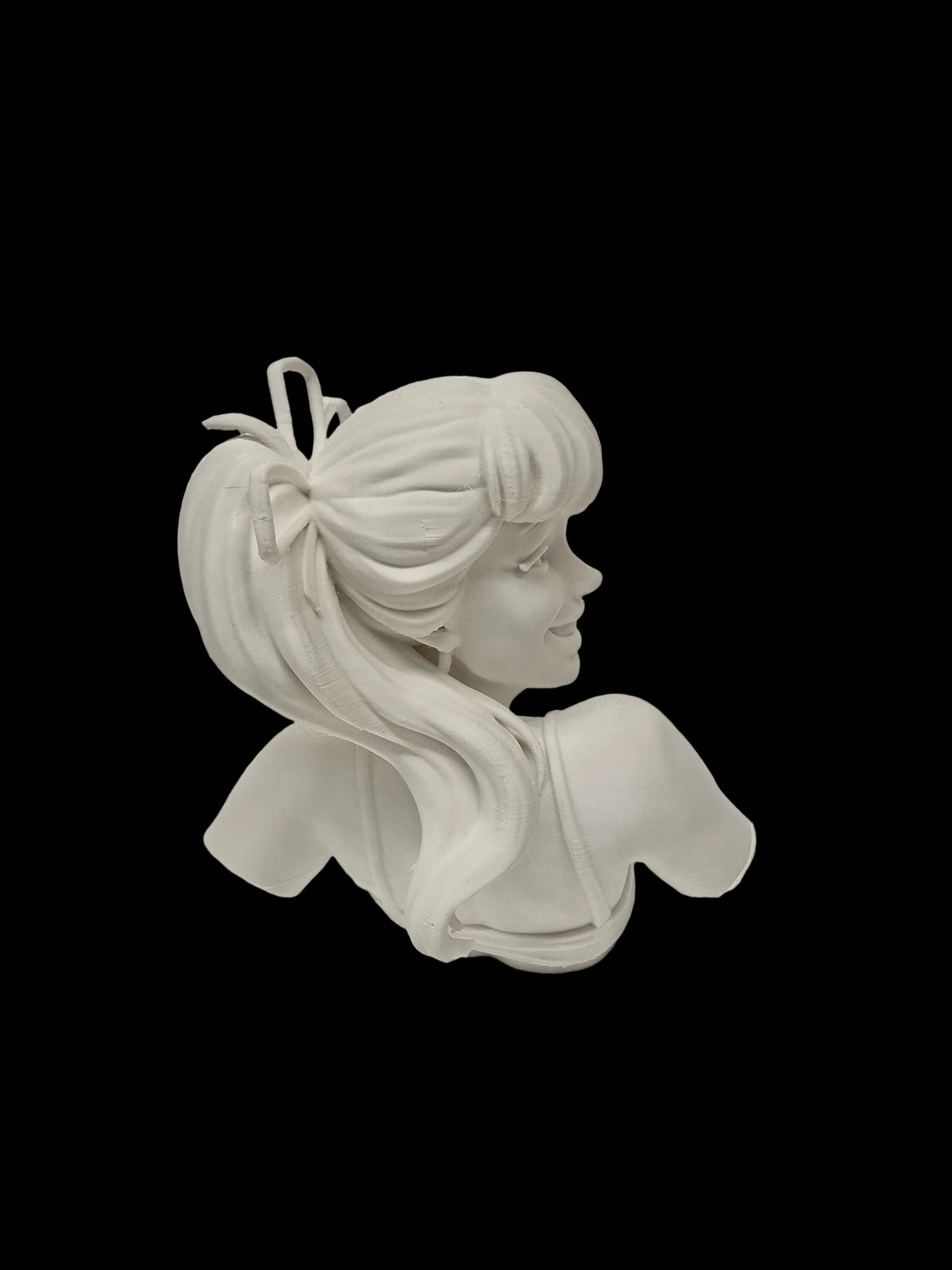 A white 3D-printed female bust figurine with a high ponytail and bow, shown from the side profile against a textured white background.