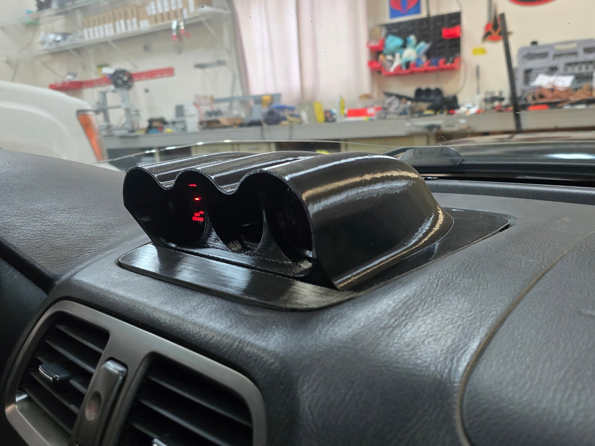 Car air vent cover on a car dashboard with a garage in the background
