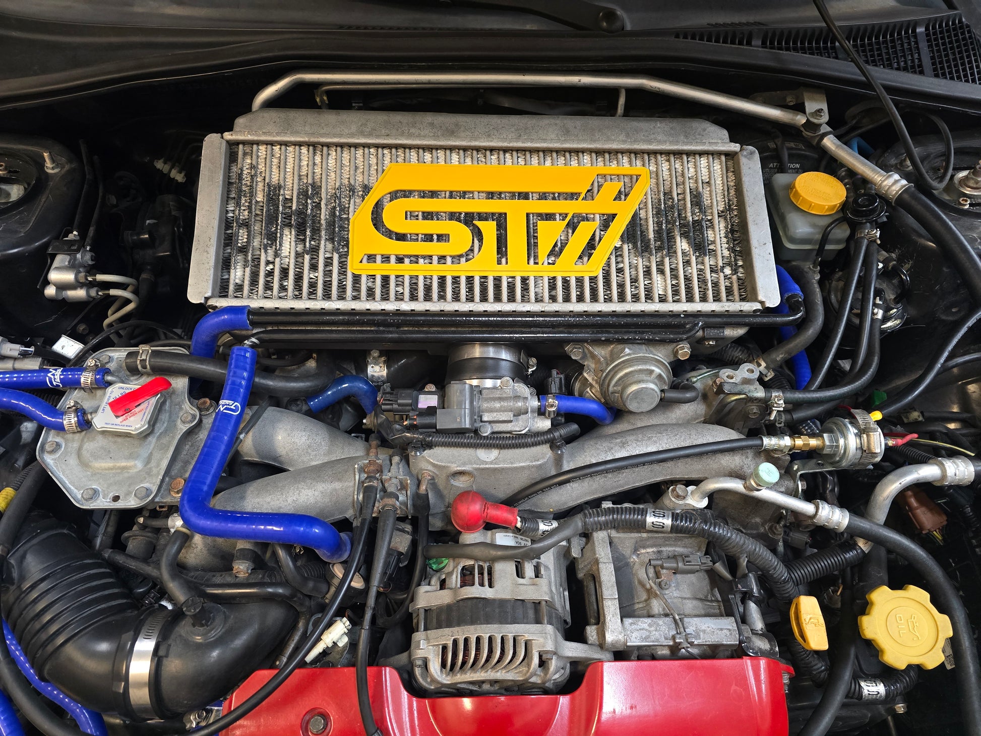 Car engine with a prominently displayed STI logo on the radiator.