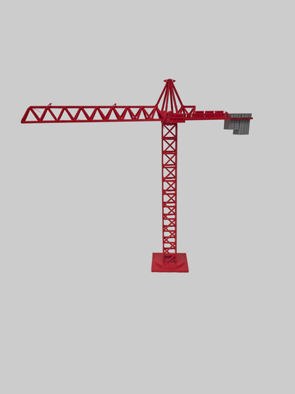 Red model of a construction crane against a textured white wall
