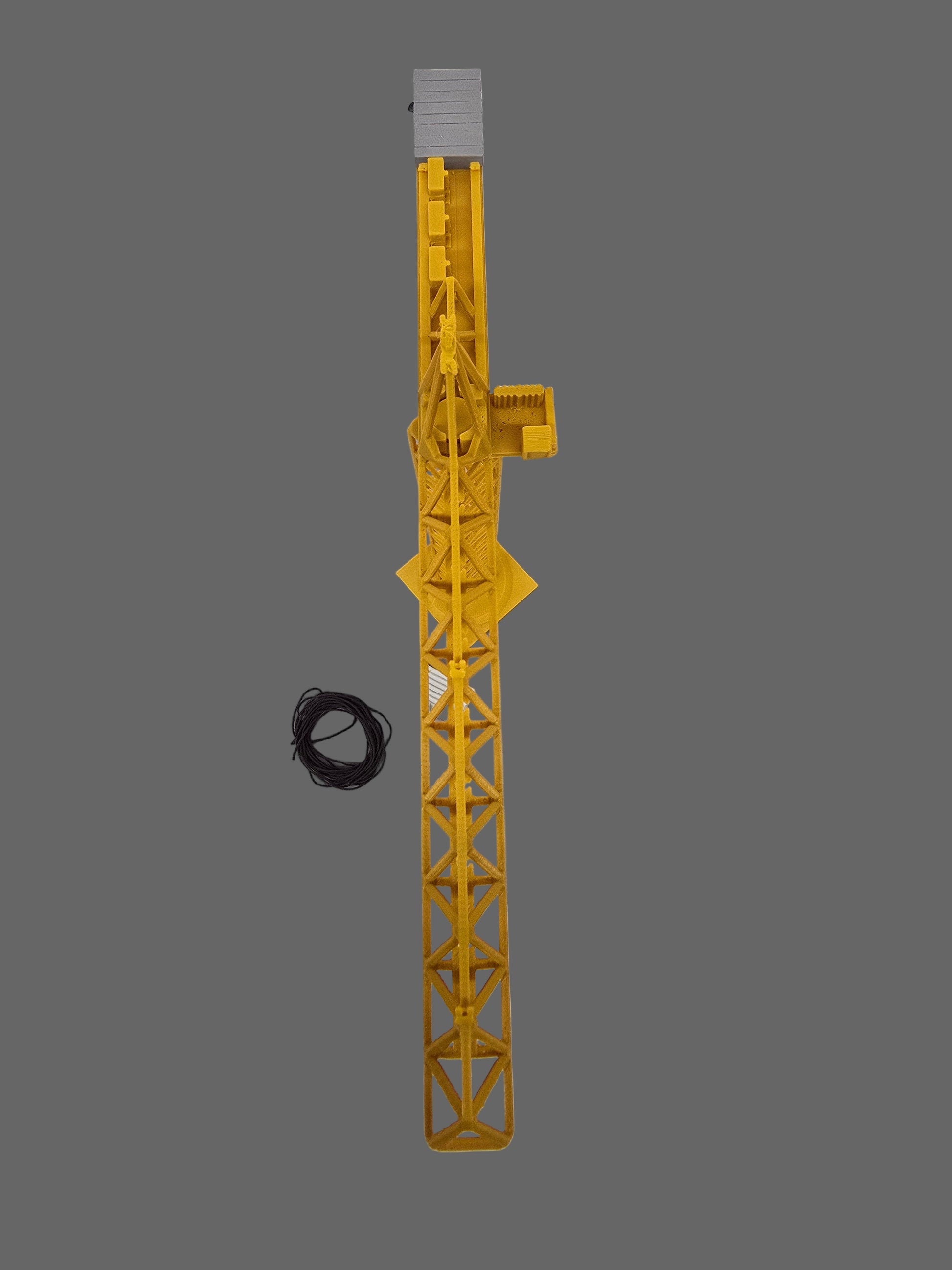 Yellow crane model on a gray square platform with tools on a light gray background